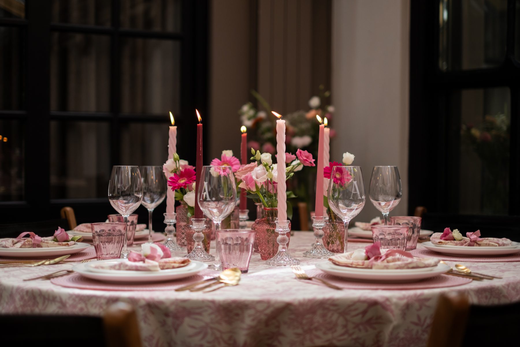 Volledig overzicht van de roze dinertafel met bloemen en kaarsen