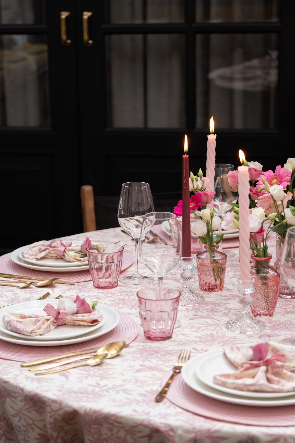 Staand beeld langs de roze tafel met bloemen en kaarsen
