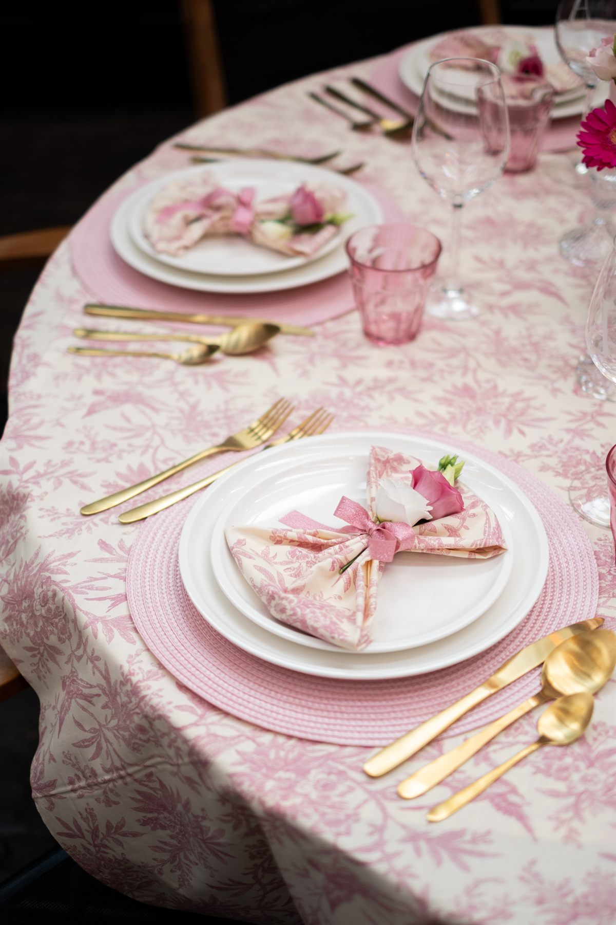 Roze couvert met gebloemd servet en gouden bestek