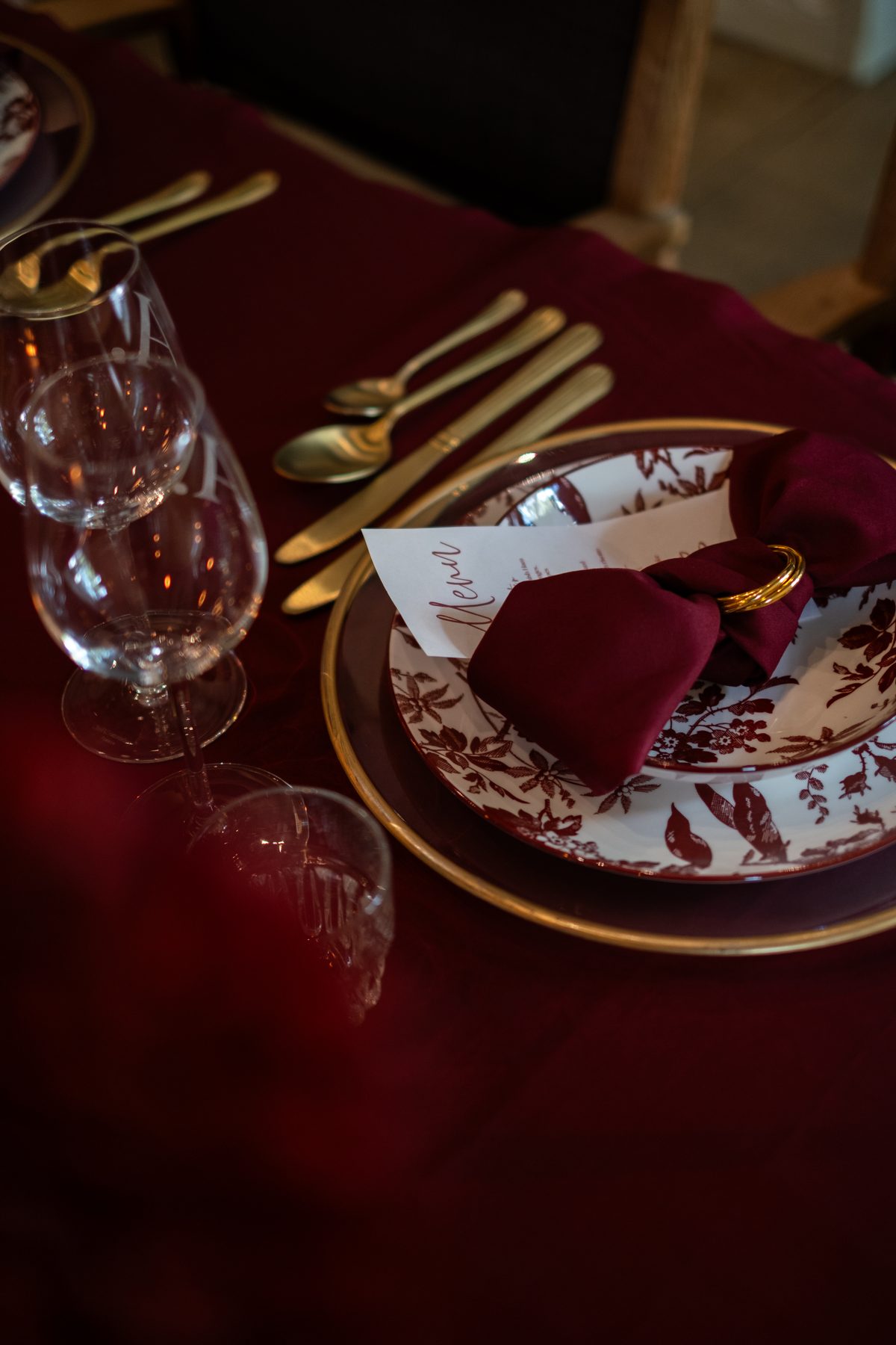 Close-up van bordeaux servies, servet, menukaart en gouden bestek