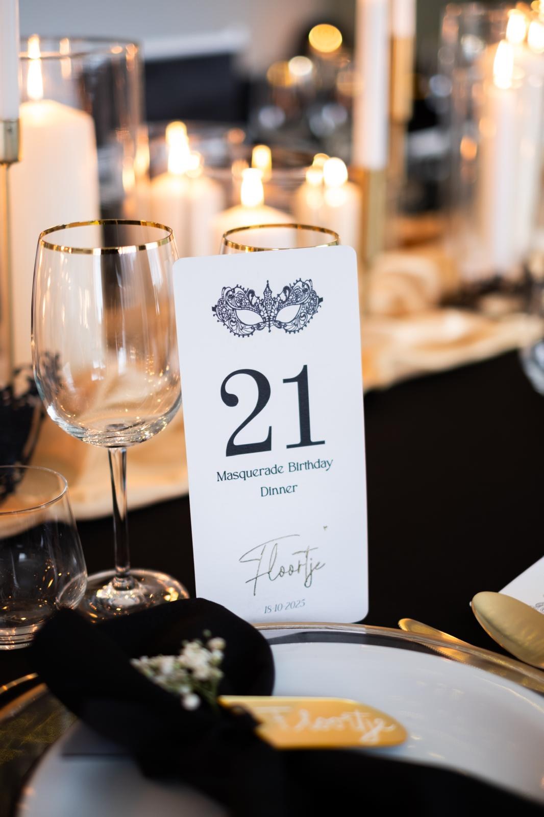 Kaart voor een masquerade 21-diner tussen gouden glazen