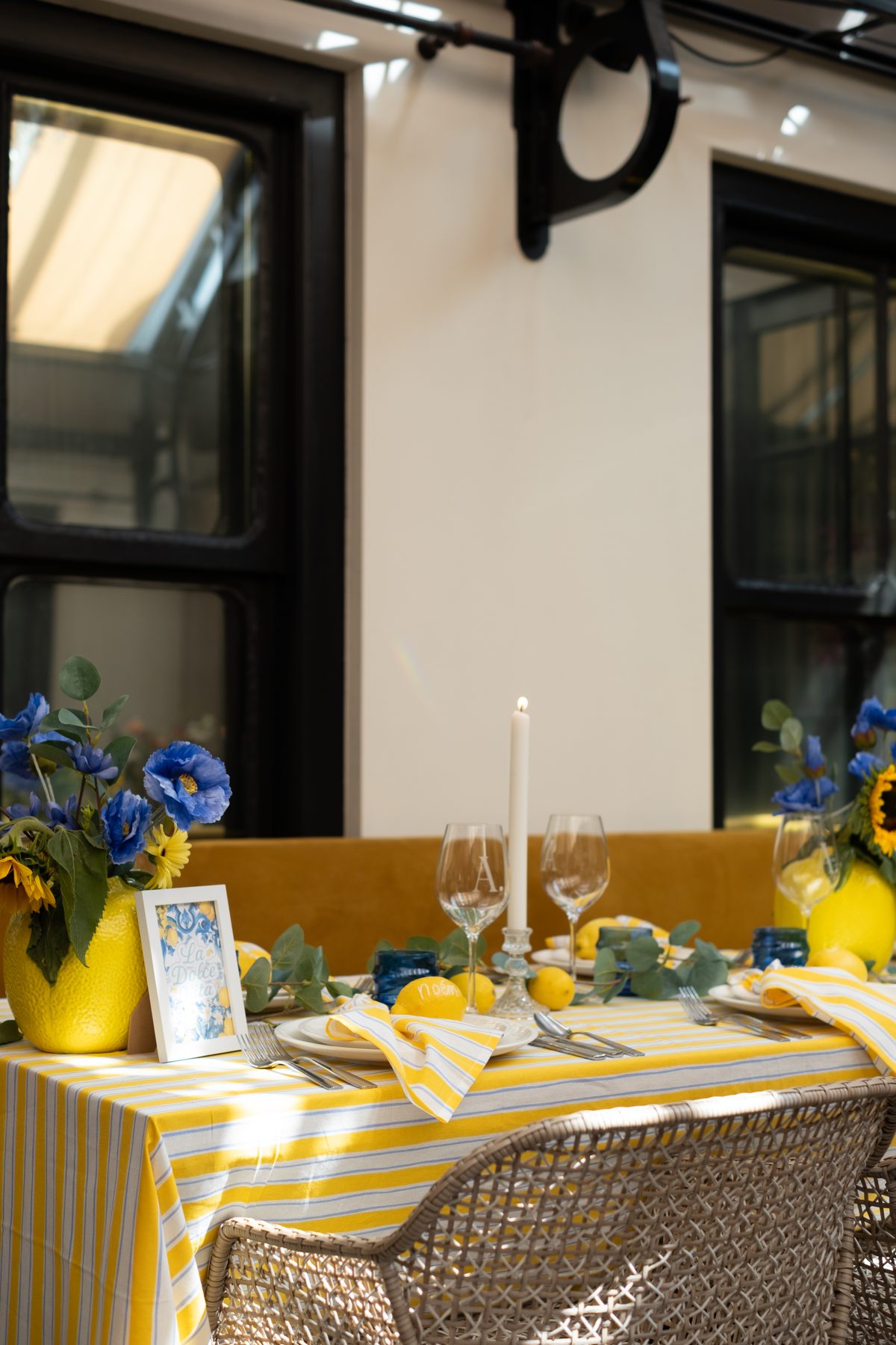 Geelblauwe tafel met bloemen, citroenen en glaswerk