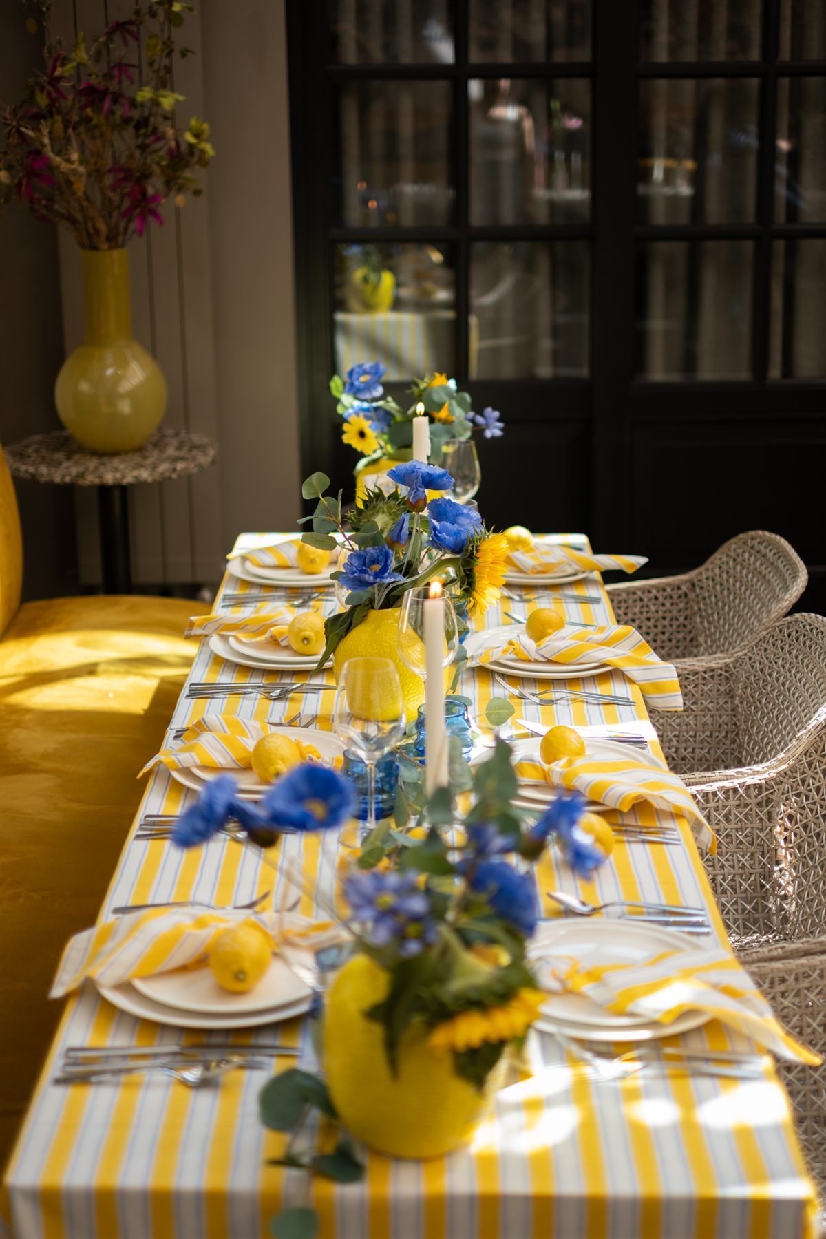 Zonnige tafelsetting met citroenen en blauwe bloemen