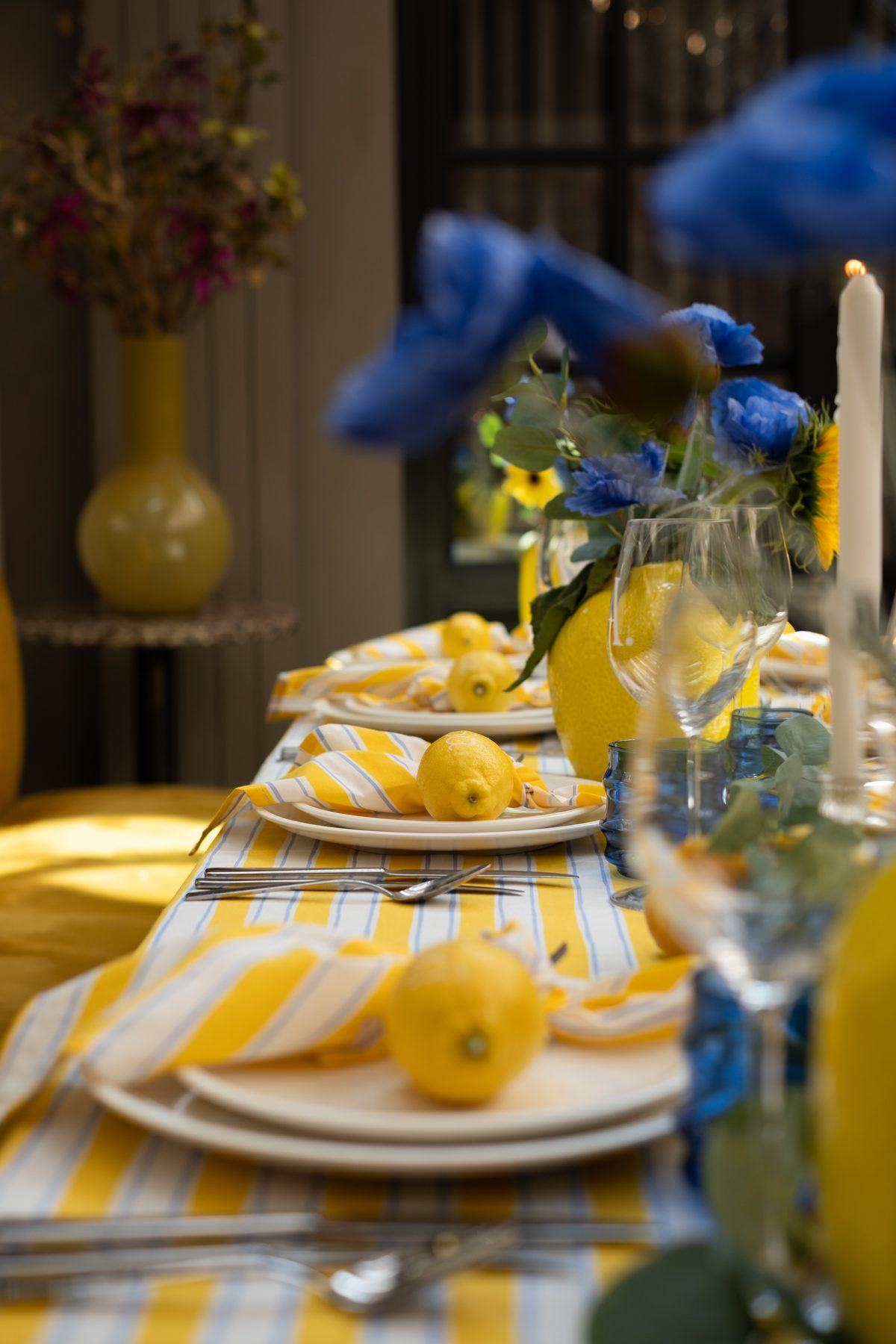 Citroenen en blauwe bloemen langs de geelblauwe tafel