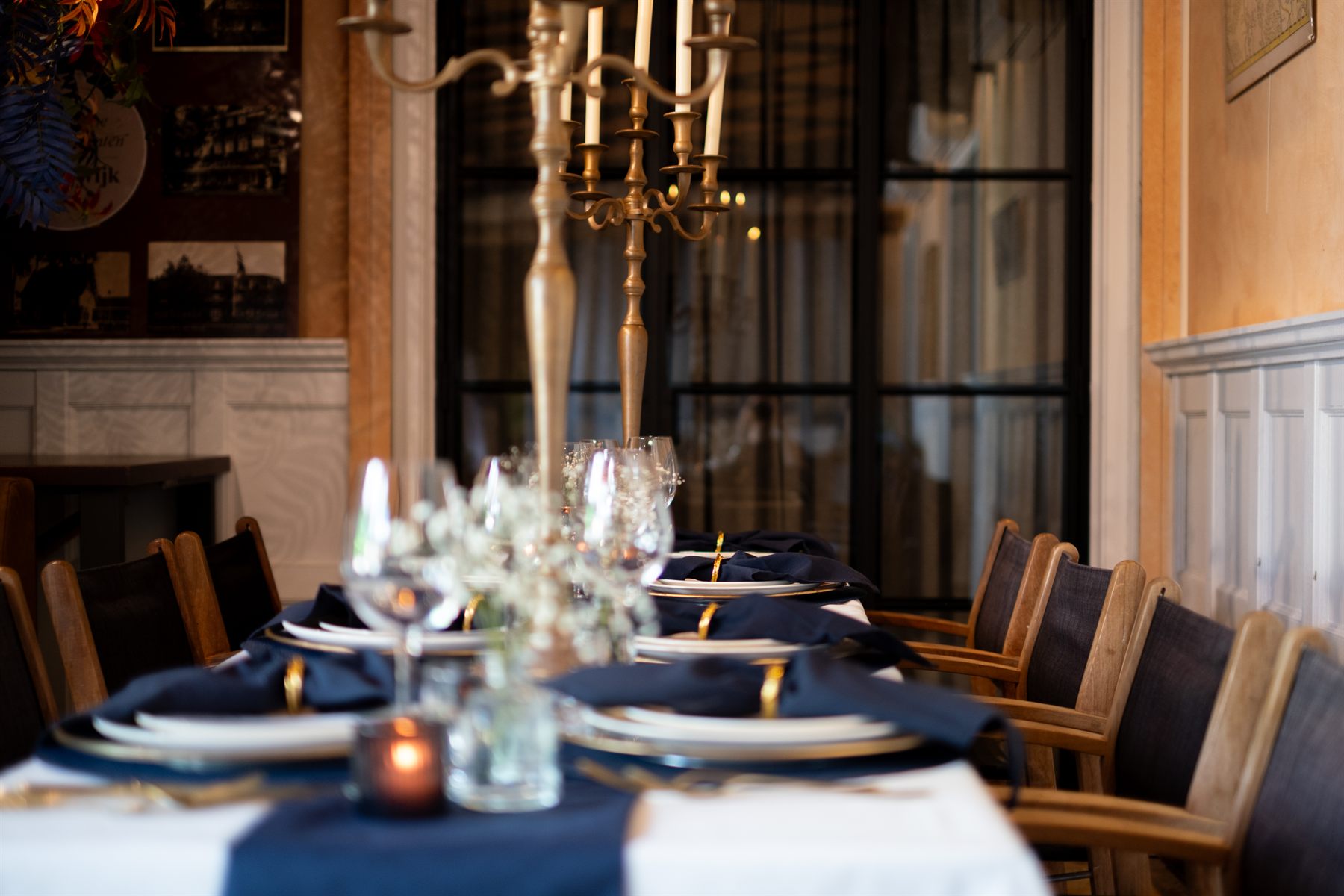 Overzicht van een lange dinertafel met donkerblauwe servetten