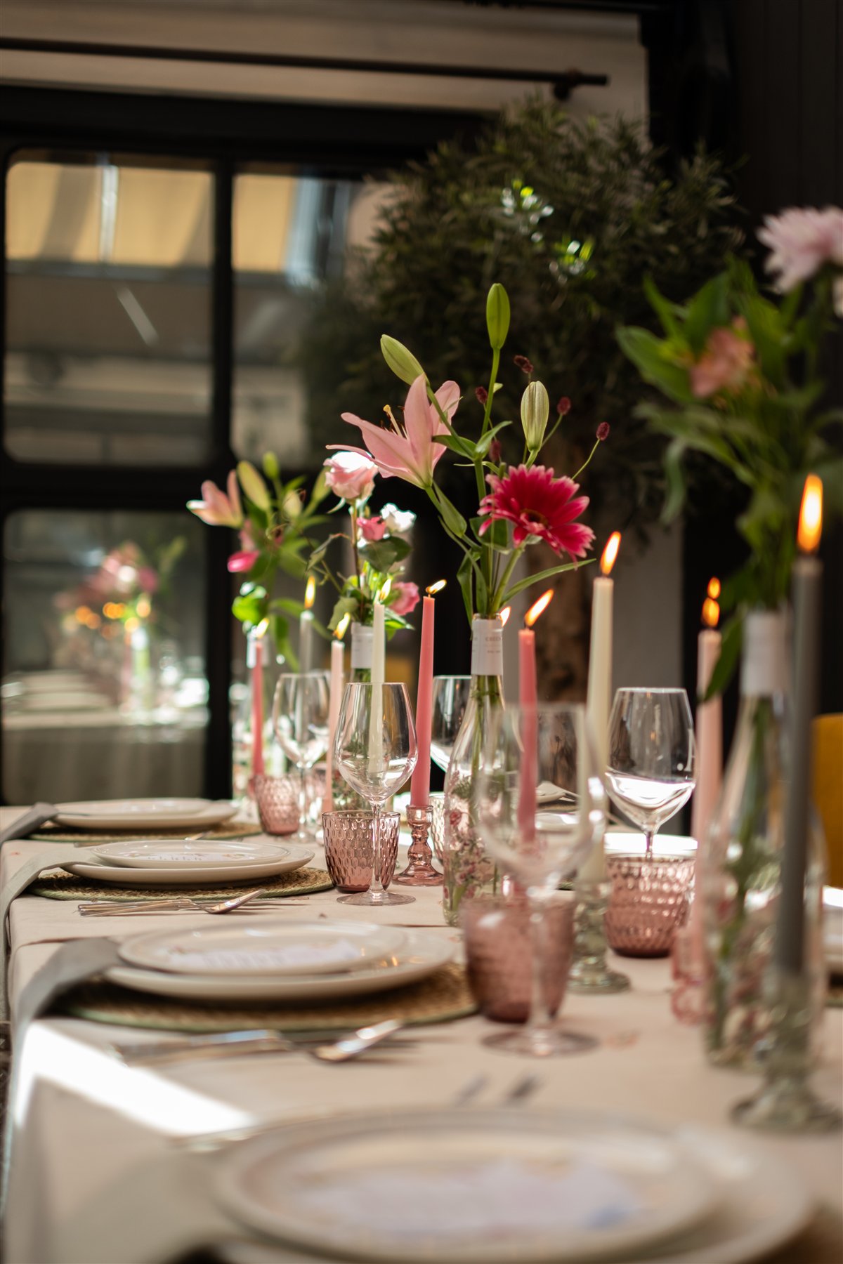 Zicht vanaf de linkerzijde langs de gedekte tafel met bloemen en gekleurde kaarsen