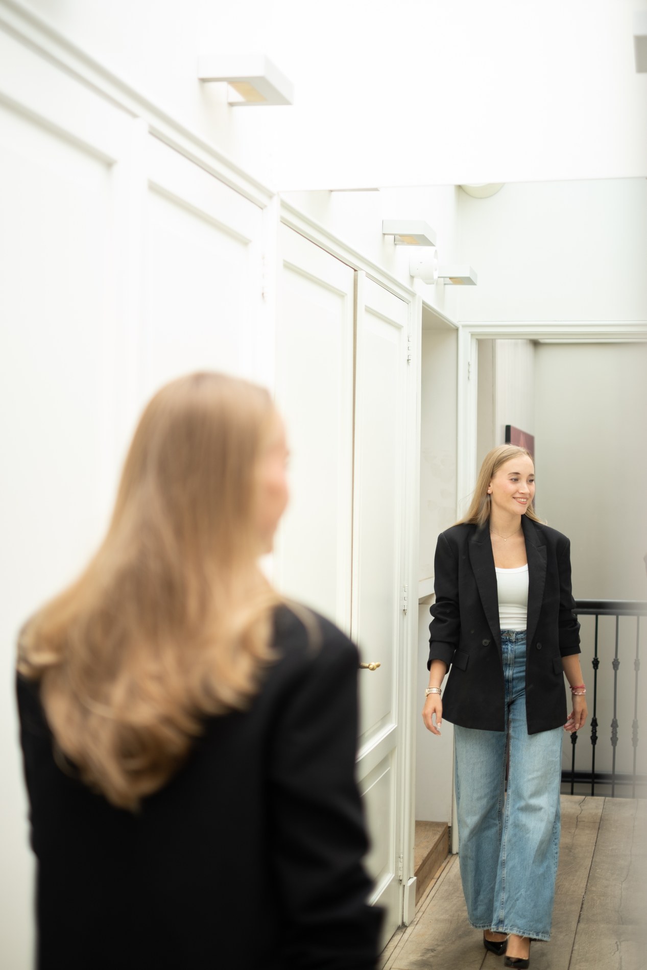 Floortje loopt lachend langs een spiegel